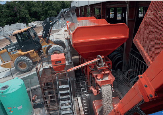 A front end loader refills one of two aggregate bins